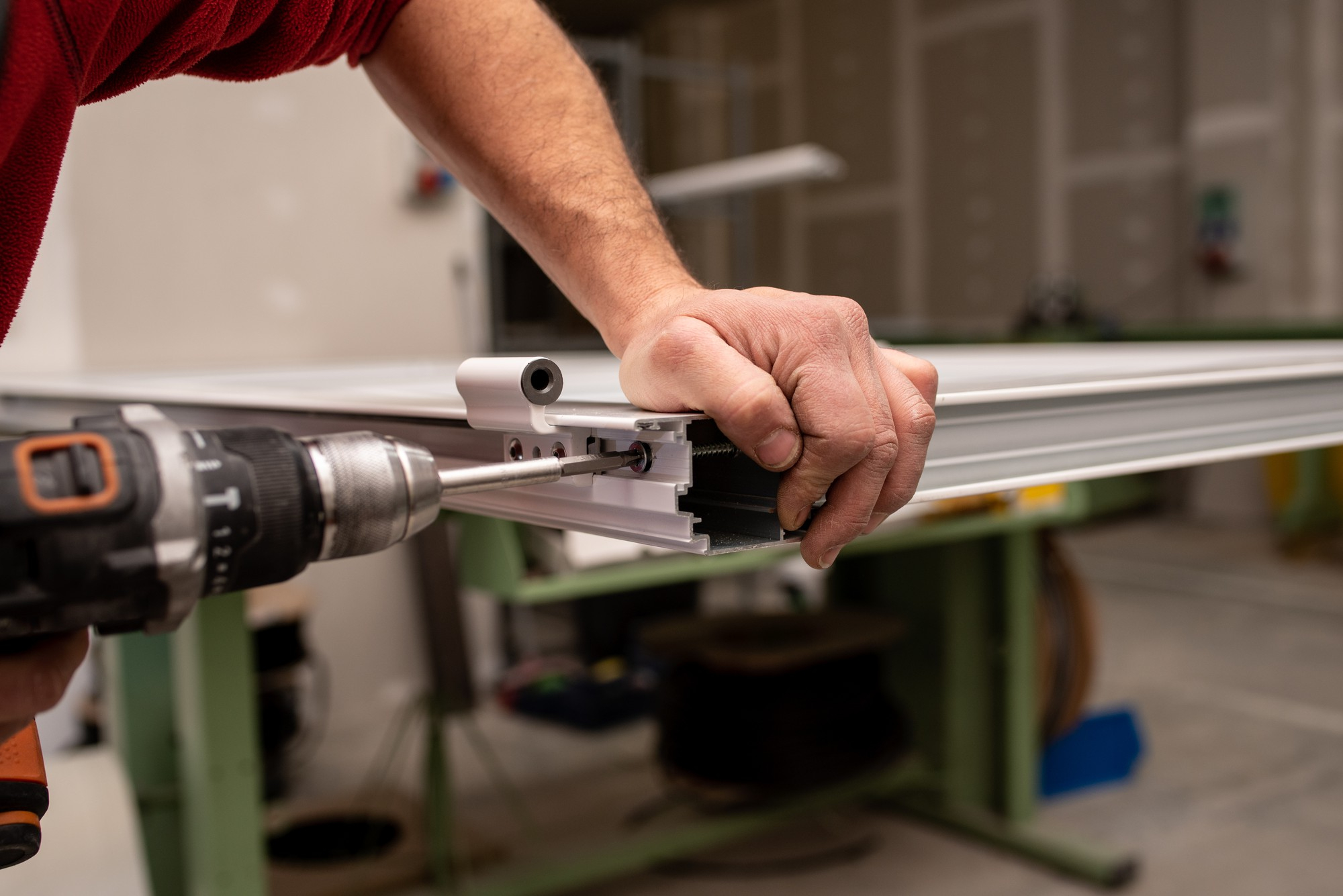 Perfil de aluminio siendo ensamblado con taladro